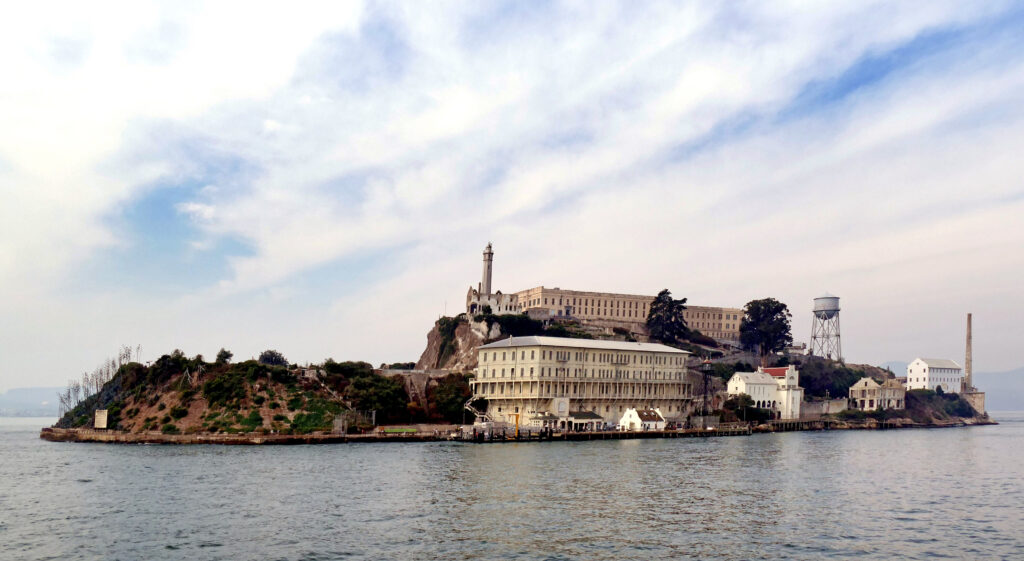 Alcatraz Island from the water, with the cellhouse, the lighthouse, and the water tower