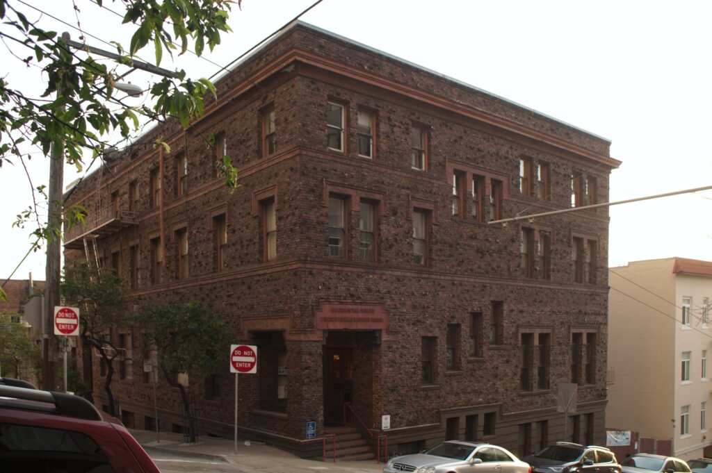 The dark brick building of Cameron House on the corner at 920 Sacramento Street