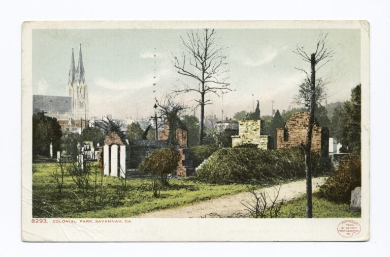 A hand-colored postcard of old brick tombs and bare trees in a grassy cemetery, with church spires behind