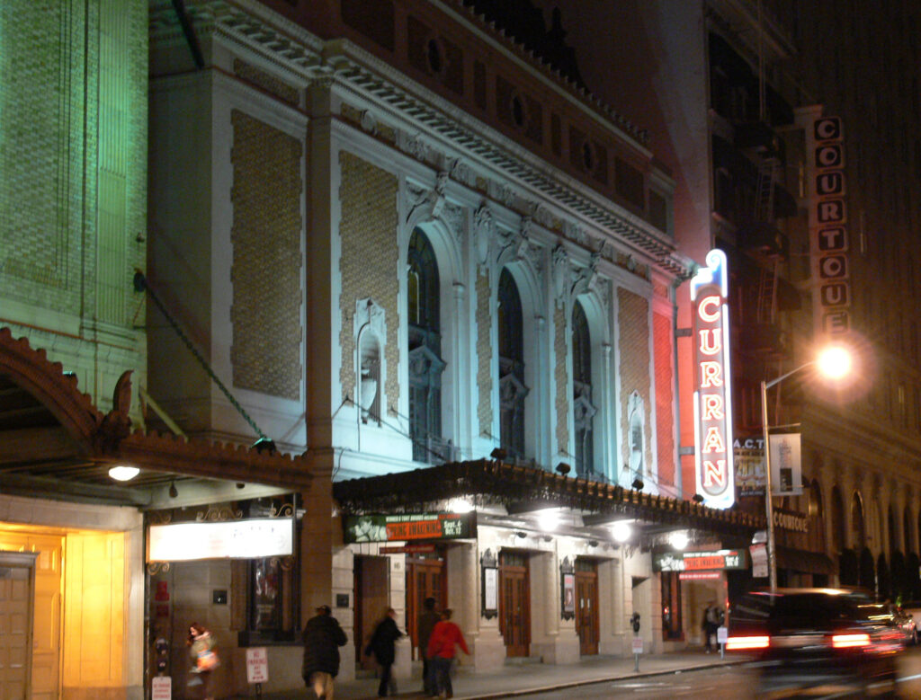 The Curran Theatre on Geary Street lit up at night, with its vertical sign and marquee