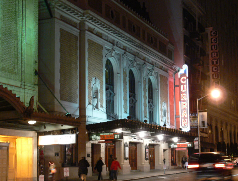 The Curran Theatre on Geary Street lit up at night, with its vertical sign and marquee
