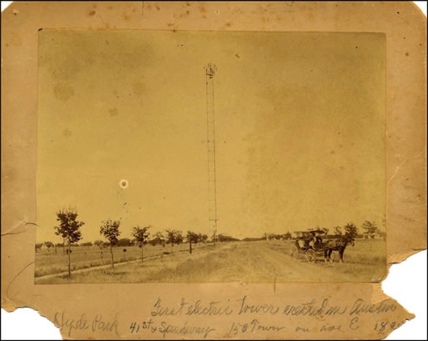 A faded 1895 photograph of a thin iron tower standing over a dirt road, a horse and buggy, and a row of young trees