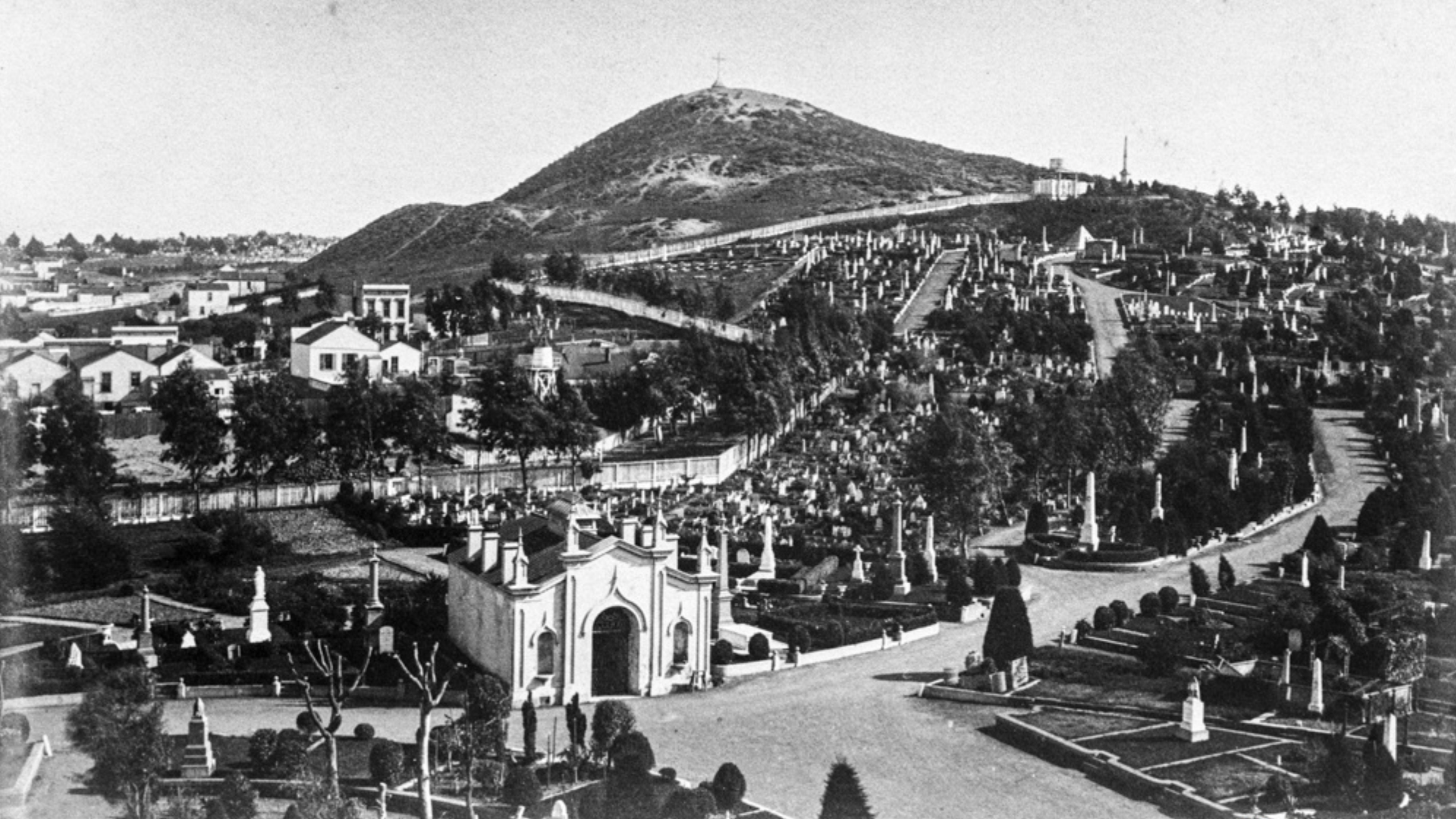 A view over the monuments and paths of the Odd Fellows Cemetery in San Francisco, taken between 1879 and 1891, with a hill behind
