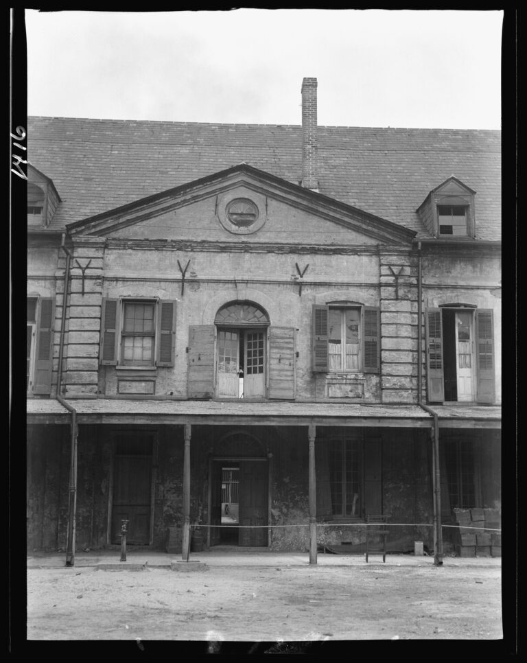 The two-story front of the Old Ursuline Convent, with a pediment, dormers and a ground-floor gallery, in black and white