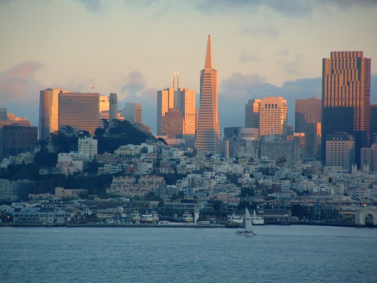 The downtown San Francisco skyline at sunset, seen across the water, with the Transamerica Pyramid at its center