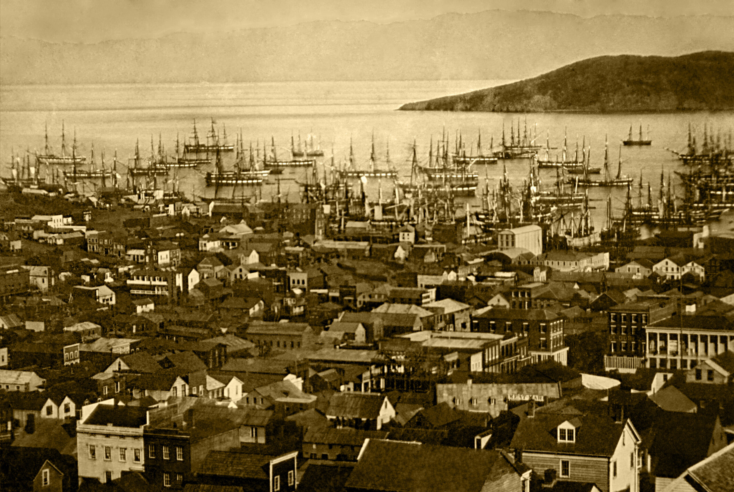 A daguerreotype from about 1851 of Yerba Buena Cove packed with the masts of abandoned ships, with the town's rooftops in the foreground